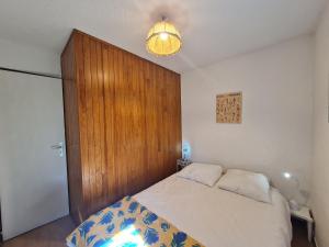a bedroom with a bed and a wooden door at Sequoias - 102 - Appart moderne 4 pers in Les Deux Alpes
