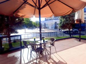 een tafel en stoelen op een balkon met een parasol bij Dedepark Hotel in Eskisehir