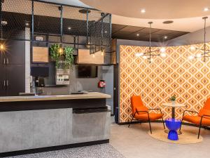 uma cozinha com duas cadeiras laranja e um balcão em Hotel ibis Bragança em Bragança