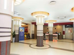 una hall con colonne e soffitti a cupola in un centro commerciale di ibis Sibir Omsk Hotel a Omsk