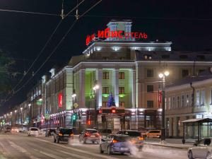 a building with a neon sign on top of it at ibis Sibir Omsk Hotel in Omsk