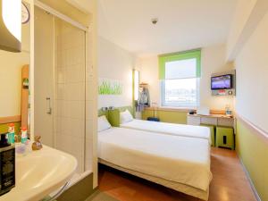 um quarto com uma cama, uma banheira e um lavatório em ibis budget Krakow Stare Miasto em Cracóvia