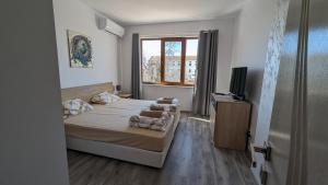 een kleine slaapkamer met een bed en een televisie bij Apartment DEVA in Balchik