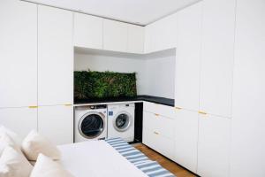 eine weiße Waschküche mit Waschmaschine und Trockner in der Unterkunft Wohlfühloase in perfekter Lage in Stuttgart
