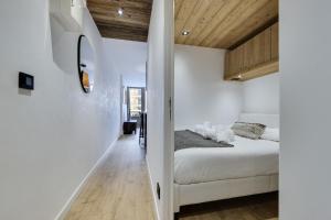 a bedroom with white walls and wooden ceilings at Résidence Le Rosset - 2 Pièces pour 4 Personnes 254 in Tignes