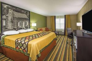 a hotel room with a large bed and a flat screen tv at Super 8 by Wyndham Paragould in Paragould