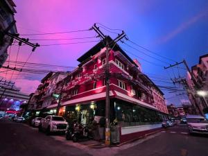 een roze gebouw in een stadsstraat 's nachts bij Baipho Lifestyle in Patong Beach