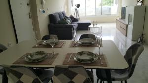 una mesa de comedor con platos y vasos. en Luxury Apartment HDA Golf Resort - Los Olivos H 007, en Fuente Alamo