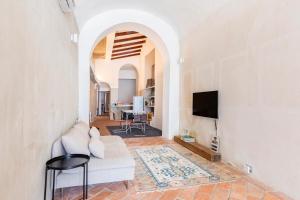 a living room with a white couch and a tv at Loft 33 in Piacenza