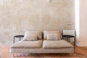 a couch with two pillows in a room at Loft 33 in Piacenza