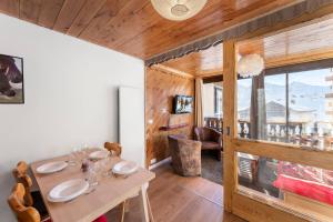 une salle à manger avec une table et une grande fenêtre dans l'établissement Résidence Le Serac - Studio pour 4 Personnes 294, à Val Thorens