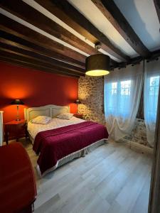 um quarto com paredes vermelhas e uma cama com lençóis vermelhos em Gîte De Chevreuse em Chevreuse
