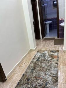 a bathroom with a rug on the floor and a bathroom with a toilet at سكن تله الظاهره in Al Madinah
