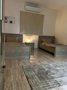 1 Schlafzimmer mit 2 Betten und einem Tisch mit einem Teppich in der Unterkunft سكن تله الظاهره in Medina