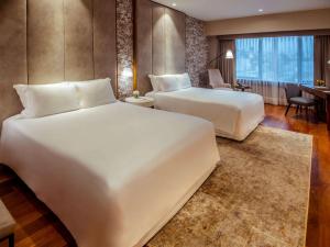 una camera d'albergo con due letti e una scrivania di Manto Hotel Lima - MGallery Collection a Lima Altre 37 foto