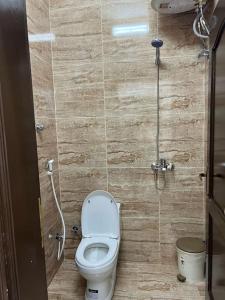 a small bathroom with a toilet and a shower at سكن تله الظاهره in Al Madinah