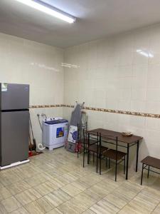 eine Küche mit einem Kühlschrank sowie einem Tisch und Stühlen in der Unterkunft سكن تله الظاهره in Medina