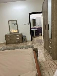 a bedroom with a bed and a mirror and a sink at سكن تله الظاهره in Al Madinah