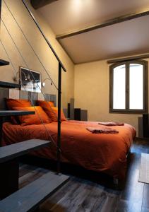 a bedroom with a bed with an orange comforter at Maison de charme en centre-ville 4 à 6 personnes in Arles