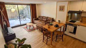 a living room with a table and a couch at Le Tucou - Gîte & Spa Tout confort in Campan