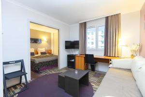 a hotel room with a bed and a desk at Aparthotel Chez Adagio Paris La Défense-2P with Terrace in Courbevoie
