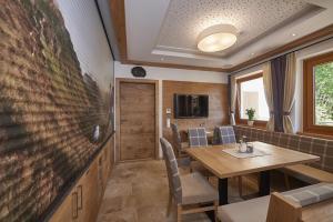 jadalnia ze stołem i dużym telewizorem w obiekcie Pension Gabi w Saalbach Hinterglemm