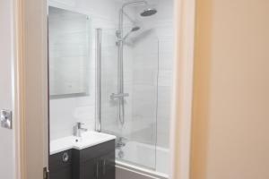 a white bathroom with a shower and a sink at Tower Hotel in Lincoln +39 photos