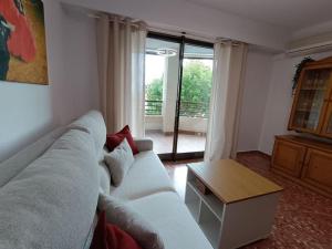 a living room with a white couch and a table at Pueblo Español in Cullera