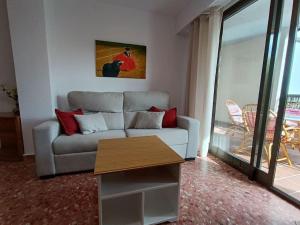 a living room with a couch and a table at Pueblo Español in Cullera +13 photos