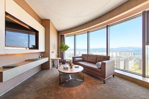 a living room with a couch and a table at Kunming Huiyue Wyndham Hotel in Kunming