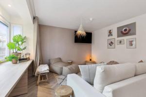 un salon avec un canapé blanc et une table dans l'établissement Raphaelle - trendy appartement met 2 slaapkamers, à Ostende