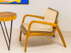 uma cadeira de madeira ao lado de uma mesa de madeira em Ibis Styles Belém Hangar em Belém