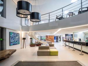 an office lobby with a staircase and a couch at Ibis Styles Belém Hangar in Belém