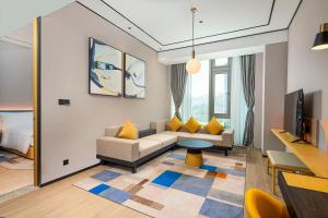 a living room with a couch and a tv at Hilton Garden Inn Shenzhen Airport in Shenzhen