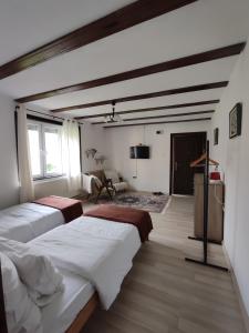 een slaapkamer met 2 bedden en een woonkamer bij Sobe RoomsBella in Ripač