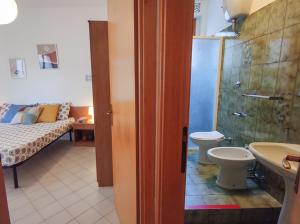 un bagno con lavandino, servizi igienici e un letto di Trilocale Volta in seconda fila mare a San Benedetto del Tronto