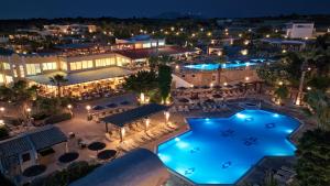 een luchtzicht op een hotel met een zwembad in de nacht bij Kouros Palace in Mastichari