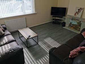 a living room with a couch and a coffee table at Stunning 3 Bedroom 5 beds House in Wolverhampton in Wolverhampton