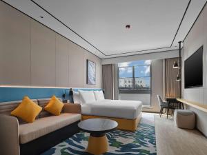 a hotel room with a couch and a bed at Hilton Garden Inn Kunming Dianchi in Kunming