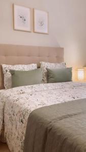 1 dormitorio con 1 cama con manta blanca y almohadas en BilboAppartment, en Bilbao