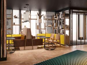 a living room with a table and chairs and yellow at Aparthotel Adagio Access Rouen Centre Cathédrale in Rouen