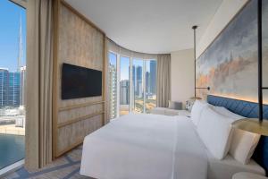 a bedroom with a large white bed and a large window at Hilton Garden Inn Dubai Business Bay in Dubai