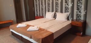 a bedroom with a large bed with two towels on it at Почивна станция Витоша in Velingrad