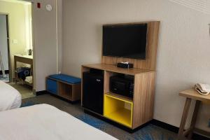 a hotel room with a television on a wall at Days Inn by Wyndham Davenport in Davenport