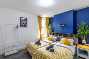2 camas en una habitación con paredes azules en Open Mind Property - Luxury House & Free Parking, en Portsmouth