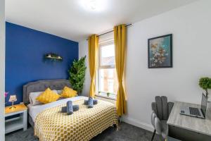 Dormitorio azul con cama y ventana en Open Mind Property - Luxury House & Free Parking, en Portsmouth