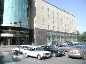 a parking lot with cars parked in front of a building at Neptun Hotel in Saint Petersburg
