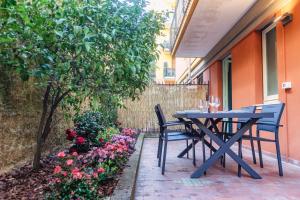 une table bleue et des chaises sur une terrasse fleurie dans l'établissement [Golfo Tigullio] Appartamento, à Rapallo
