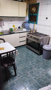 a kitchen with a stove and a table in it at Masat El Sharjah for men in Sharjah