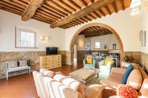 uma sala de estar com um sofá e uma mesa em Gorgeous Villa Peccioli, with private pool, AC, Wifi em Legoli